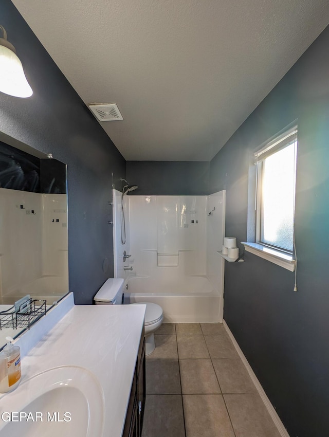 full bathroom featuring tub / shower combination, tile patterned floors, a textured ceiling, toilet, and vanity