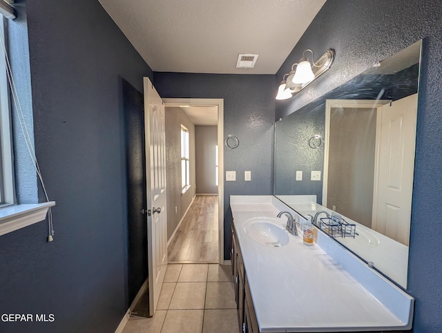 bathroom with tile patterned floors, vanity, and a textured ceiling