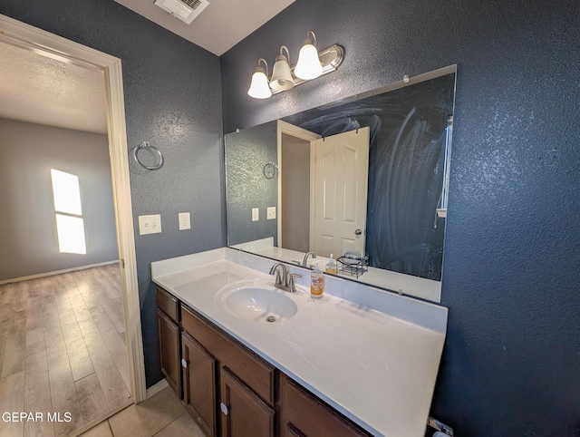 bathroom featuring a textured ceiling and vanity