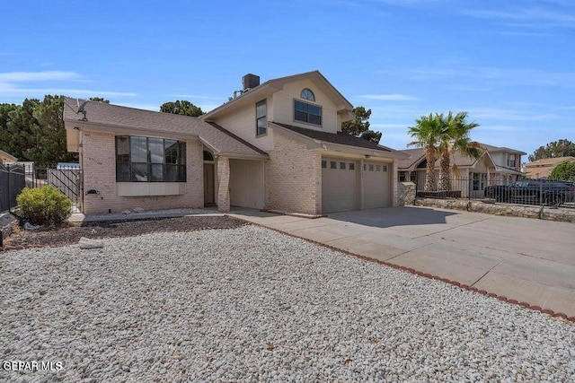 traditional-style house featuring brick siding, concrete driveway, and fence