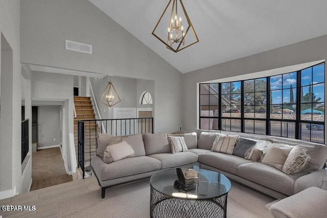 living area with stairway, visible vents, high vaulted ceiling, parquet flooring, and a notable chandelier