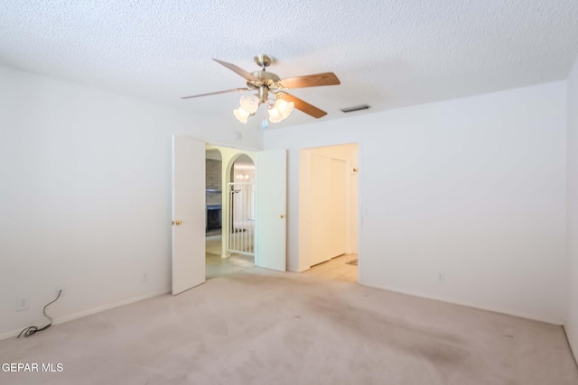 carpeted spare room featuring a textured ceiling and ceiling fan