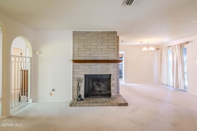 unfurnished living room with light carpet, a fireplace, and a notable chandelier