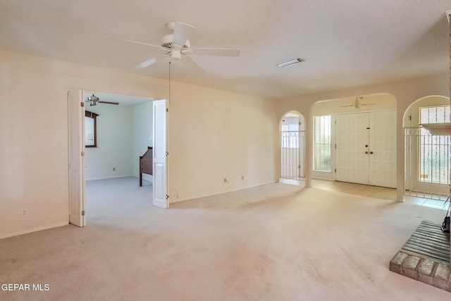 unfurnished living room featuring light colored carpet and plenty of natural light