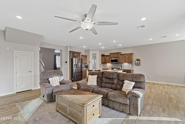 living room featuring ceiling fan and light hardwood / wood-style floors