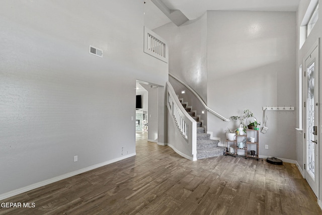 entryway featuring a towering ceiling and hardwood / wood-style flooring