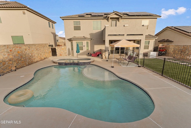 view of swimming pool featuring a patio area and an in ground hot tub