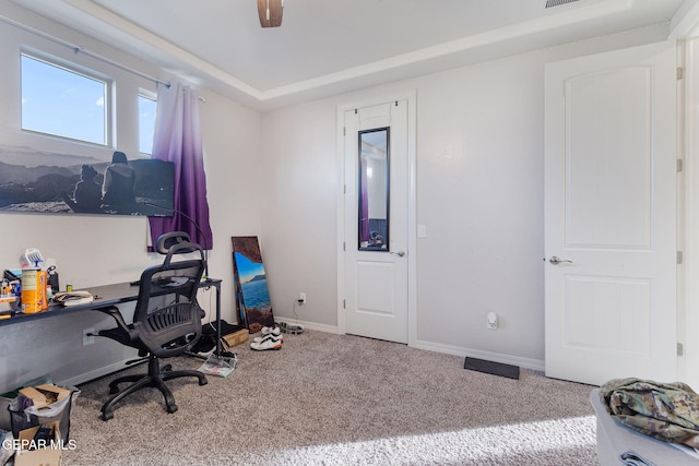 carpeted office space featuring ceiling fan