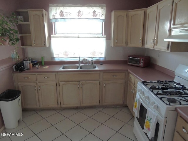 kitchen featuring light tile patterned flooring, extractor fan, gas range gas stove, and sink