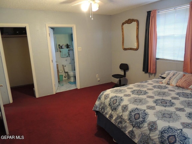 carpeted bedroom featuring a textured ceiling, ensuite bathroom, and ceiling fan