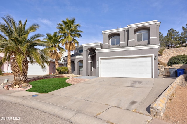 mediterranean / spanish-style home with a garage, concrete driveway, and stucco siding