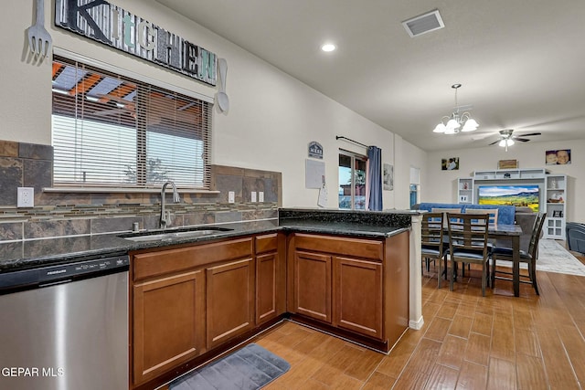 kitchen with sink, tasteful backsplash, stainless steel dishwasher, decorative light fixtures, and ceiling fan with notable chandelier