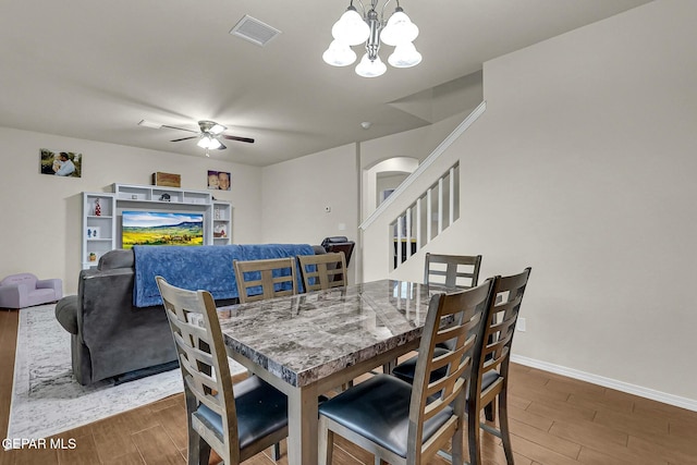 dining area with ceiling fan with notable chandelier