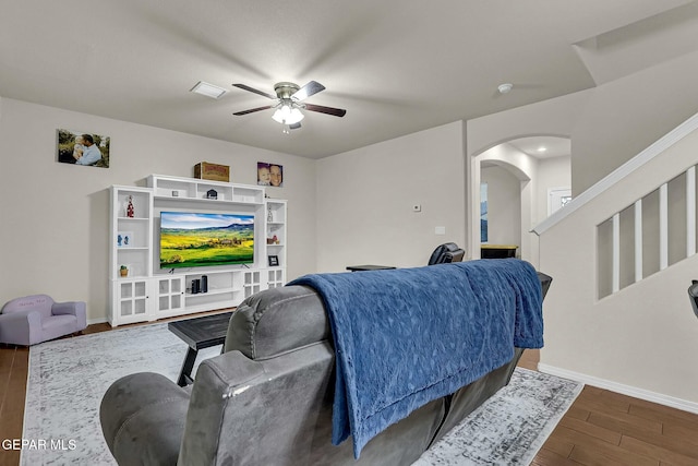 living room with ceiling fan and dark hardwood / wood-style flooring