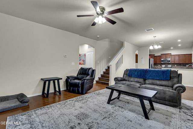 living room with ceiling fan with notable chandelier