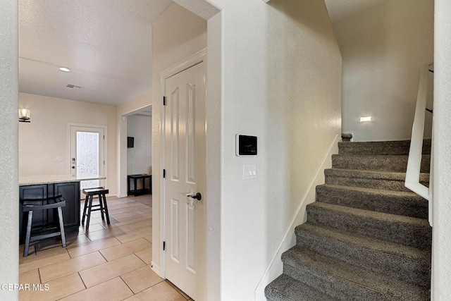 staircase featuring tile patterned flooring