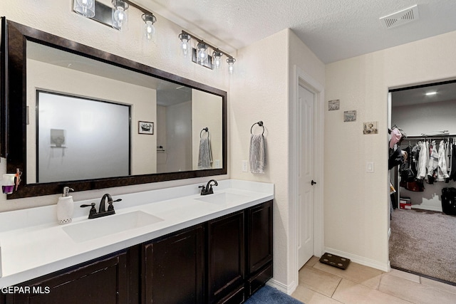 bathroom featuring vanity, a textured ceiling, and tile patterned floors