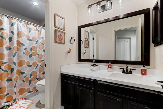 bathroom with vanity, a shower with shower curtain, and toilet