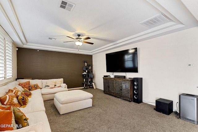 living room featuring carpet, ceiling fan, and a raised ceiling