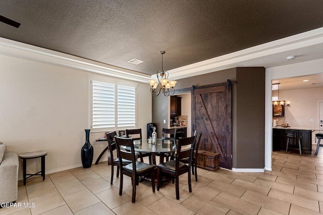 tiled dining space featuring a chandelier, a textured ceiling, a barn door, and a raised ceiling