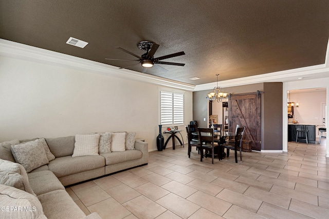 living room featuring ceiling fan with notable chandelier, a raised ceiling, a barn door, ornamental molding, and a textured ceiling