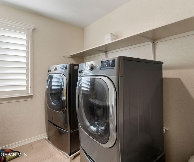 clothes washing area with light tile patterned floors and washing machine and dryer