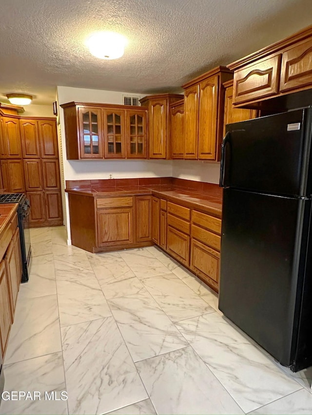 kitchen featuring a textured ceiling and black appliances