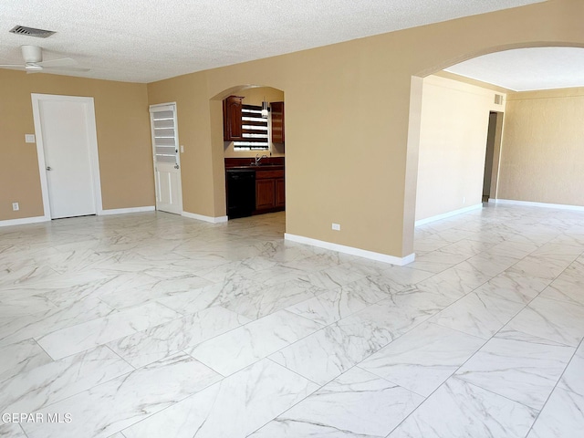 empty room featuring a textured ceiling and ceiling fan