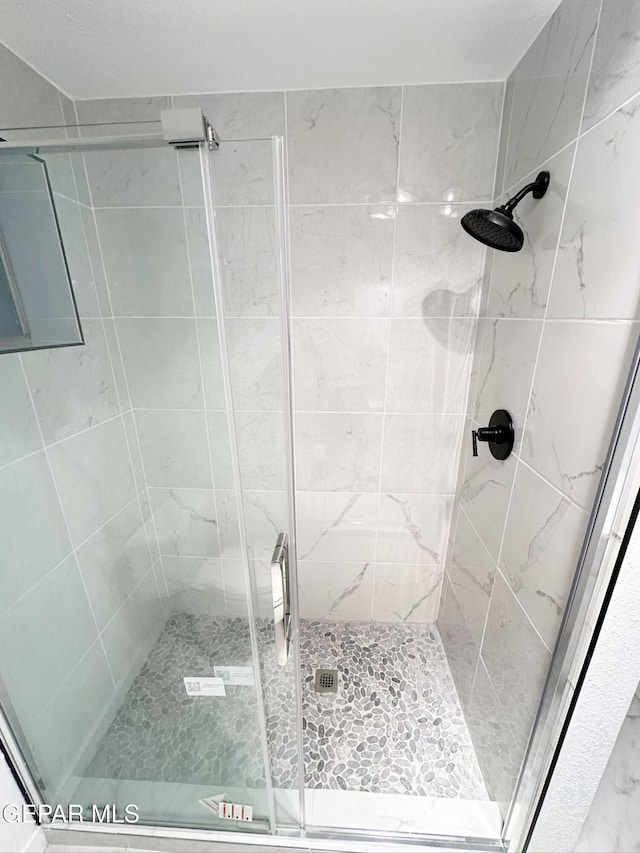 bathroom with a shower with door