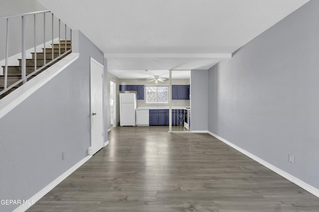 unfurnished living room featuring ceiling fan, a textured ceiling, and dark wood-type flooring