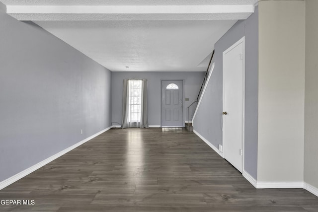 entrance foyer featuring a textured ceiling and dark wood-type flooring