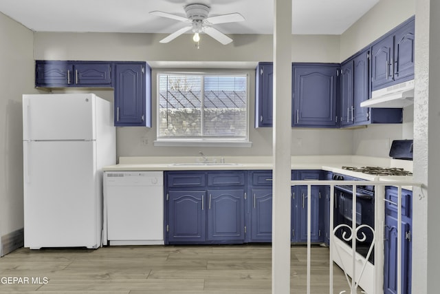 kitchen with blue cabinetry, sink, and white appliances