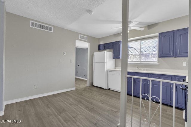 kitchen featuring white appliances, ceiling fan, sink, blue cabinetry, and light hardwood / wood-style floors