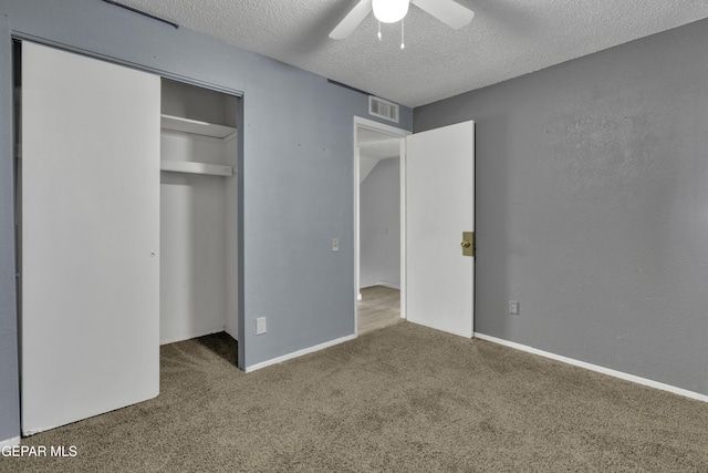 unfurnished bedroom featuring ceiling fan, carpet floors, a textured ceiling, and a closet