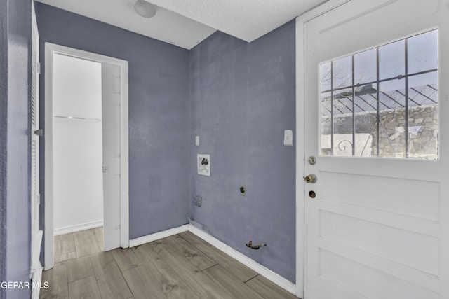 laundry area with hookup for an electric dryer, gas dryer hookup, a textured ceiling, and hookup for a washing machine