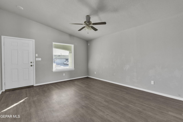 empty room featuring lofted ceiling, ceiling fan, a textured ceiling, and dark hardwood / wood-style floors