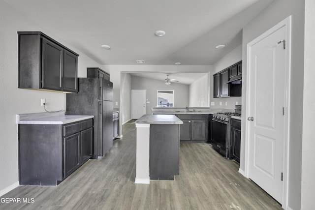 kitchen featuring ceiling fan, sink, black appliances, hardwood / wood-style flooring, and a center island