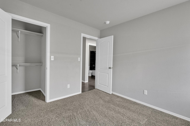 unfurnished bedroom featuring a closet and dark carpet