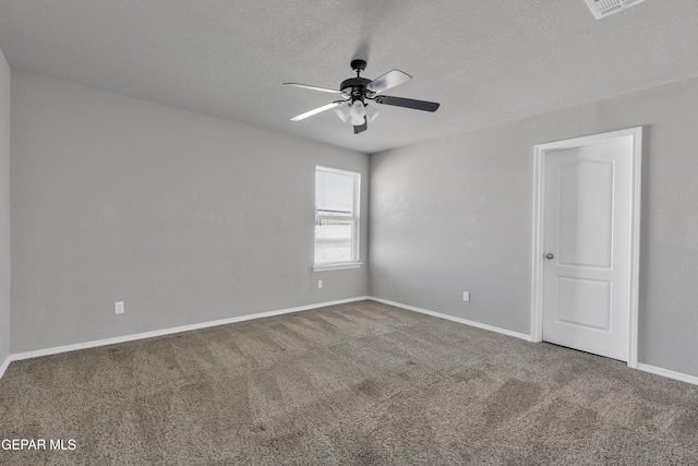 spare room featuring a textured ceiling, carpet floors, and ceiling fan