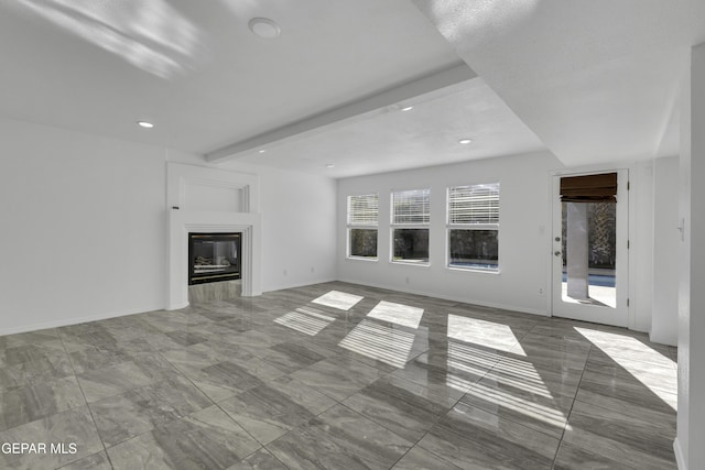 unfurnished living room with beam ceiling