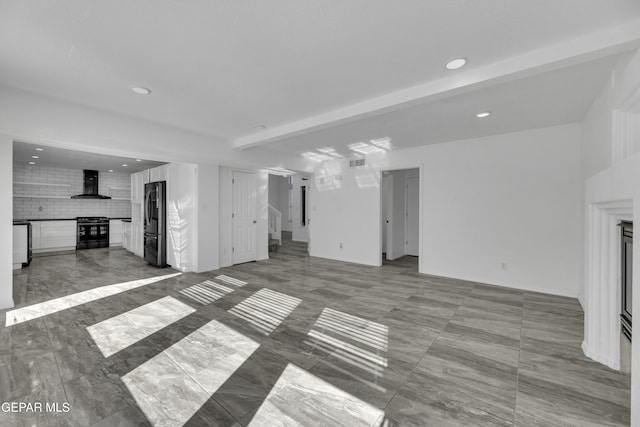 unfurnished living room with beamed ceiling