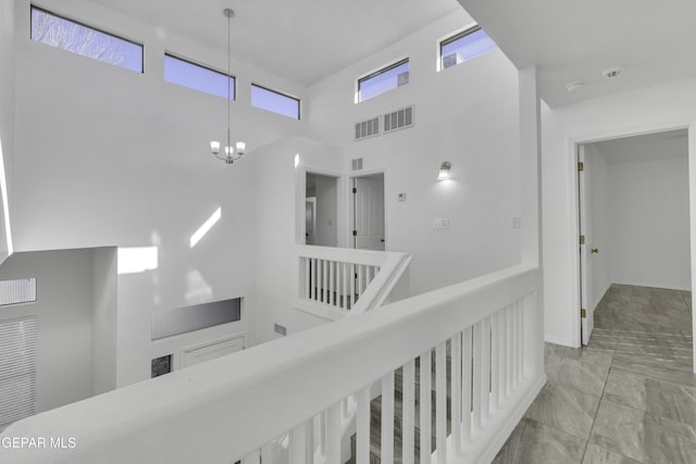 hall featuring a high ceiling and an inviting chandelier