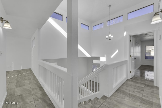 stairs with a high ceiling and an inviting chandelier