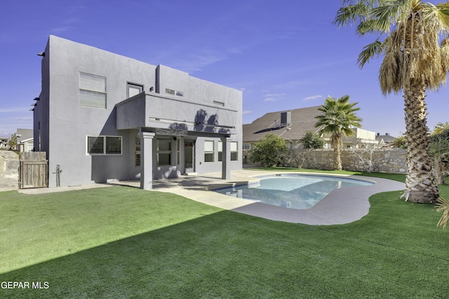 back of house featuring a lawn, a balcony, and a patio