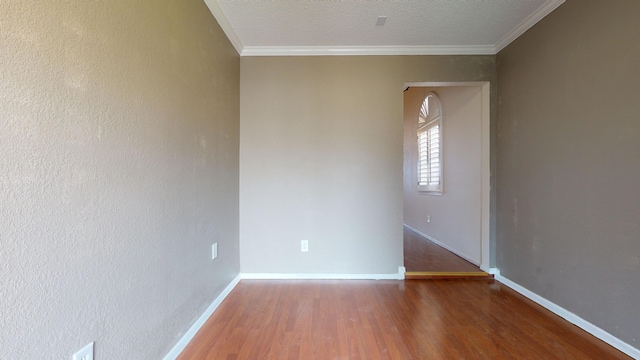 unfurnished room featuring dark hardwood / wood-style flooring, ornamental molding, and a textured ceiling