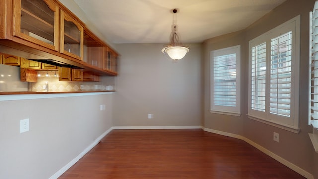 unfurnished dining area featuring dark wood-type flooring