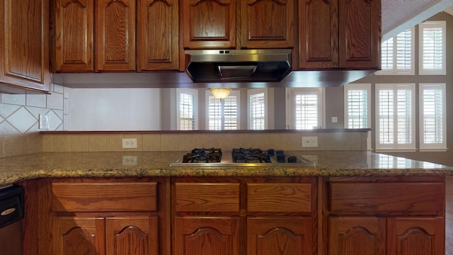 kitchen featuring light stone countertops, black dishwasher, stainless steel gas cooktop, tasteful backsplash, and extractor fan