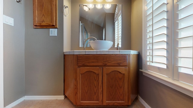 bathroom with tile patterned floors, plenty of natural light, and vanity