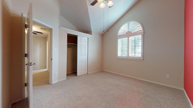 unfurnished bedroom with ceiling fan, lofted ceiling, light carpet, and a closet