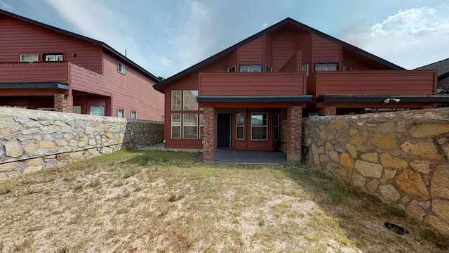 back of property featuring a balcony and a patio